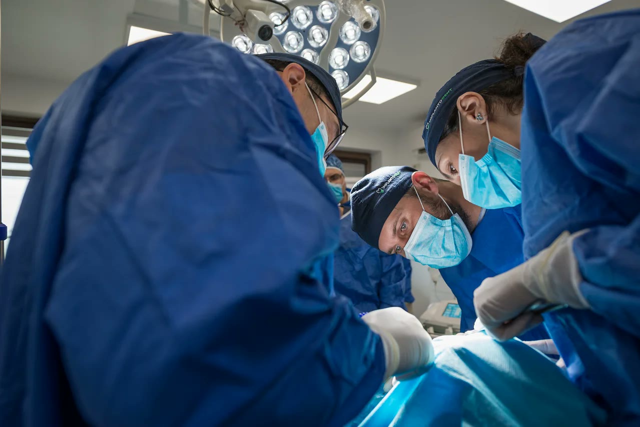 Echipa chirurgicală Implantodent în bloc operator, în timpul unei intervenții de micro-chirurgie orală