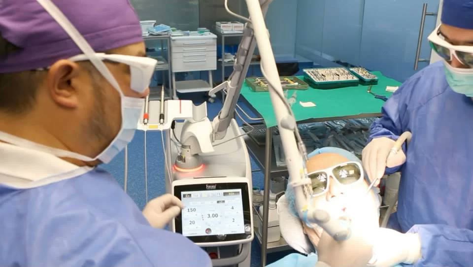 Unitate laser dentară folosită în bloc operator, cu pacientul purtând ochelari de protecție