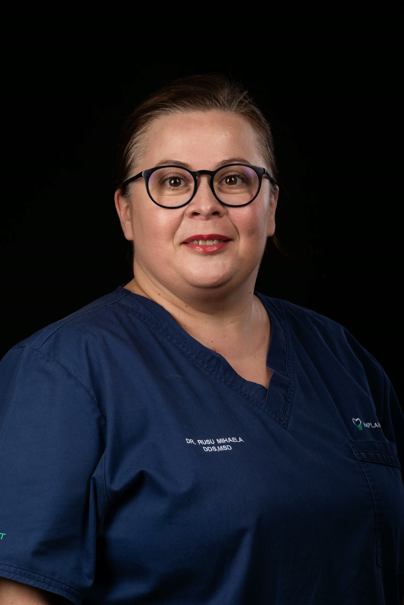Portret al dr. Rusu Mihaela, medic la Implantodent, în uniformă de clinică