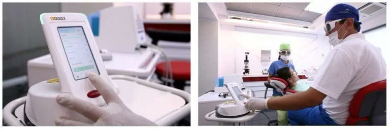 Unitatea laser cu ecran tactil și medicul care tratează pungile gingivale ale unei paciente cu laserul dentar