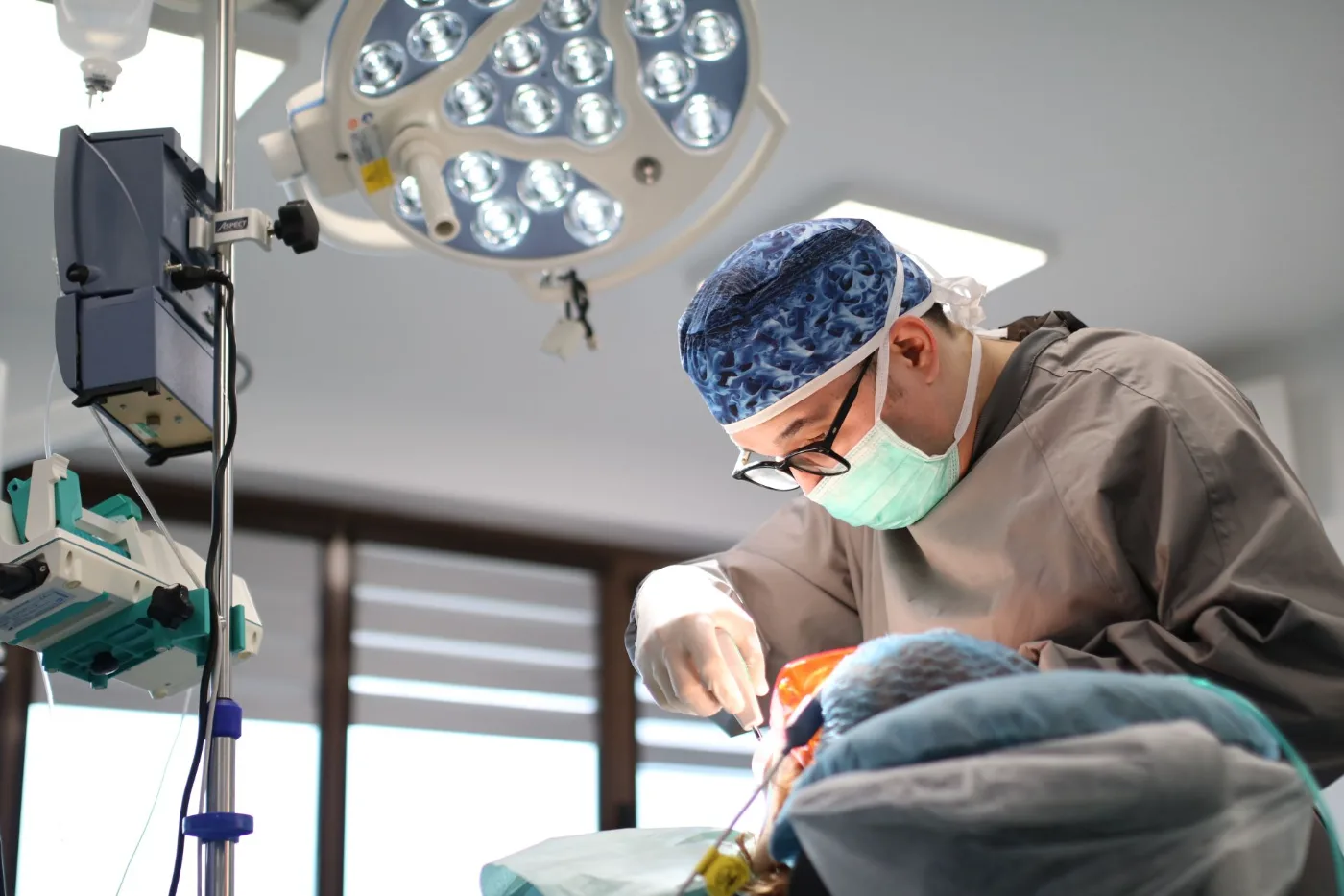 Medic implantolog inserând un implant, sub lampa blocului operator