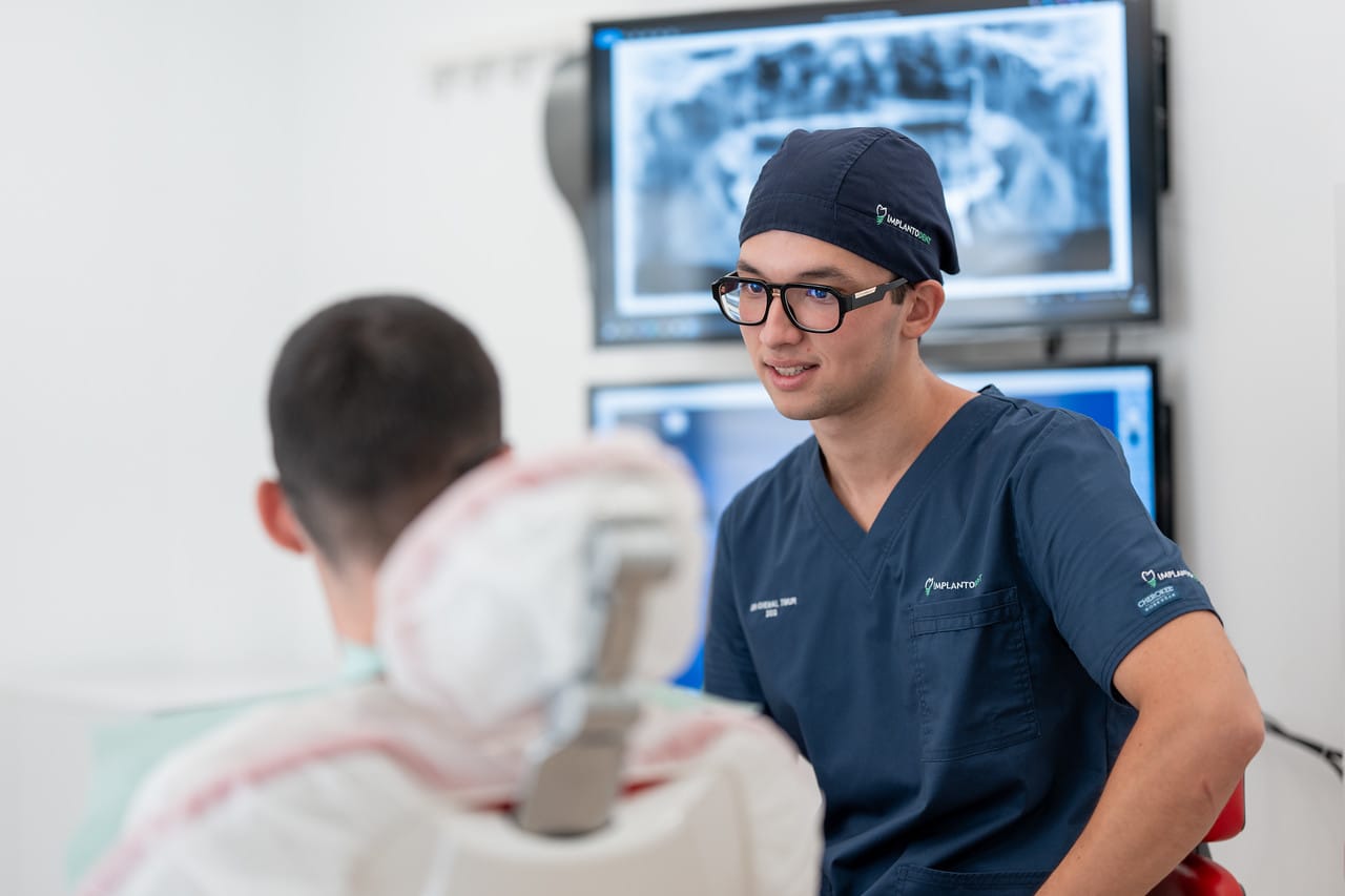 Medic Implantodent în consultație, analizând tomografia 3D a pacientului